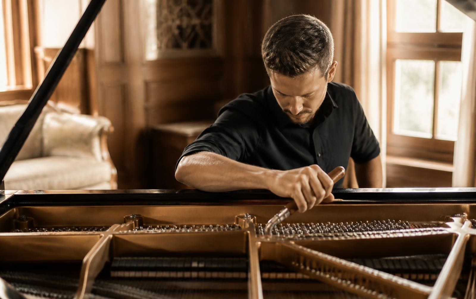 Trevorenzo Co. technician working inside a grand piano